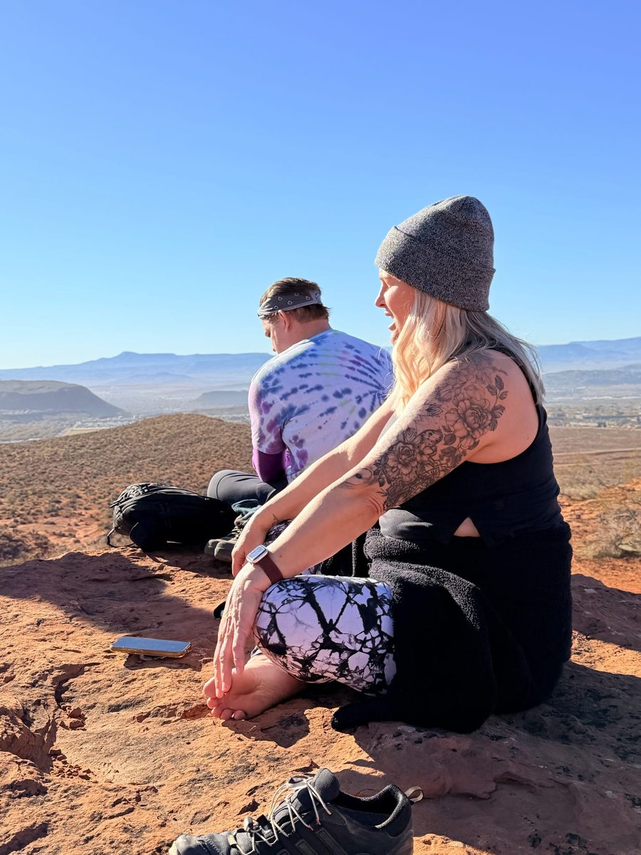Guests sitting peacefully on Utah rocks overlooking desert