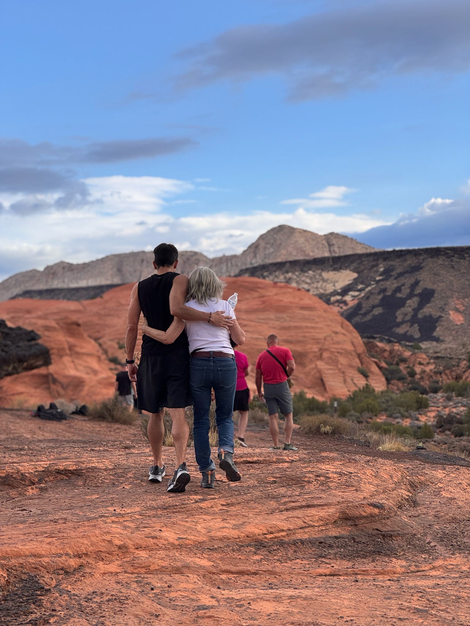 Guest walking through red rock canyons of Southern Utah during The Bridge recovery program