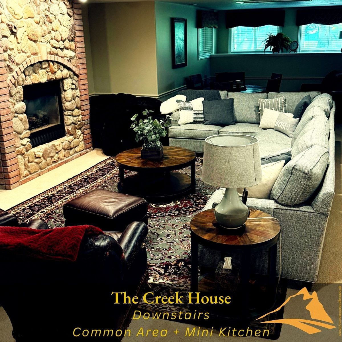 Downstairs common area with stone fireplace at The Creek House